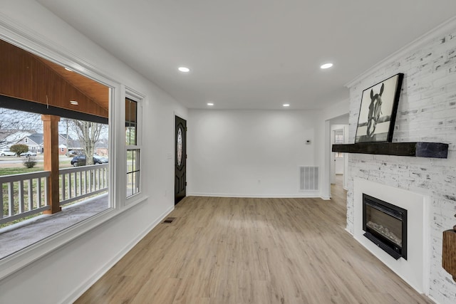 unfurnished living room featuring a fireplace and light hardwood / wood-style floors