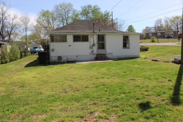 rear view of house featuring a lawn and crawl space