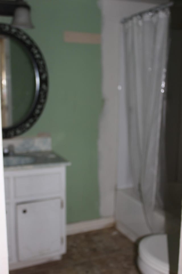 bathroom featuring baseboards, toilet, vanity, and shower / bath combo with shower curtain