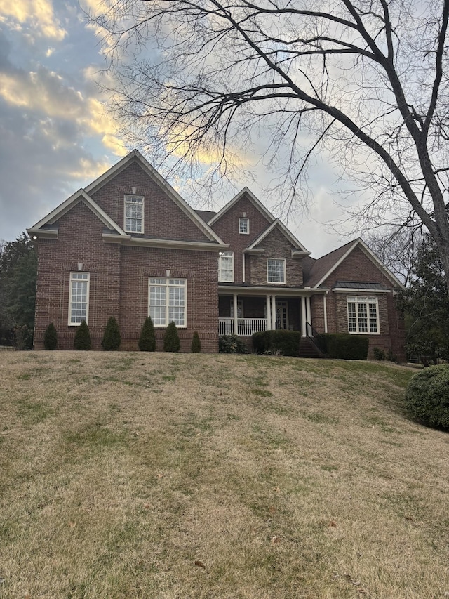 craftsman-style home with covered porch and a lawn