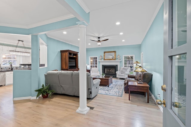 living room with ceiling fan, decorative columns, and a wealth of natural light