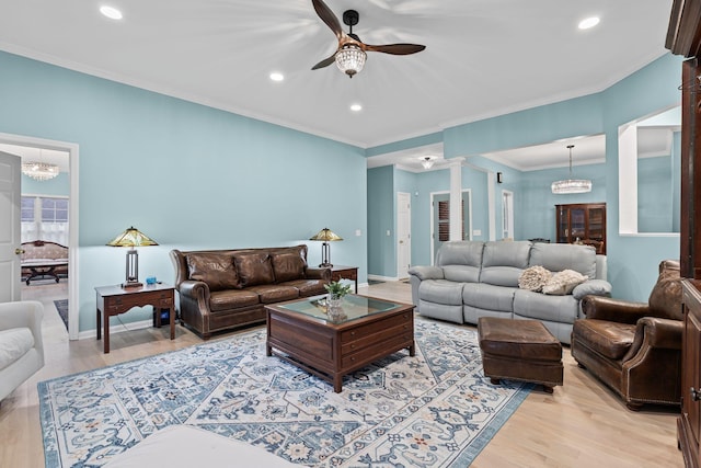 living room with decorative columns, ornamental molding, ceiling fan, and light hardwood / wood-style floors