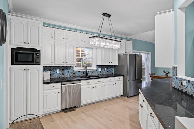 kitchen with pendant lighting, white cabinetry, stainless steel appliances, and sink