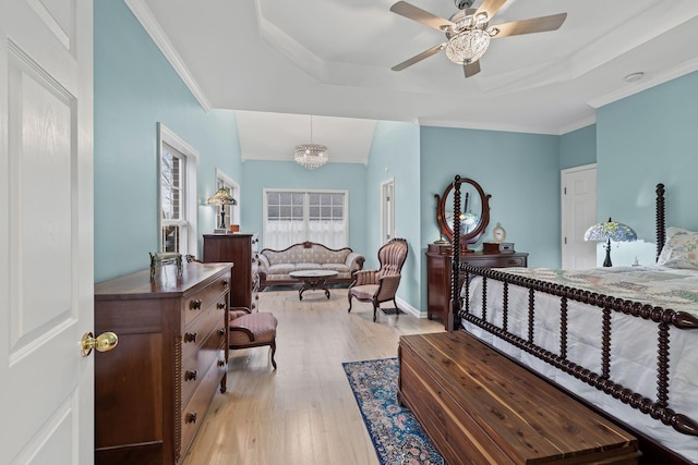 bedroom featuring ornamental molding, light hardwood / wood-style floors, and a raised ceiling