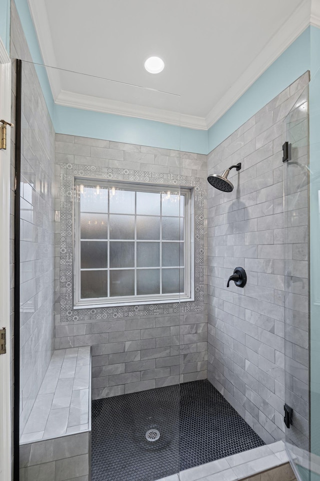 bathroom with a tile shower and crown molding