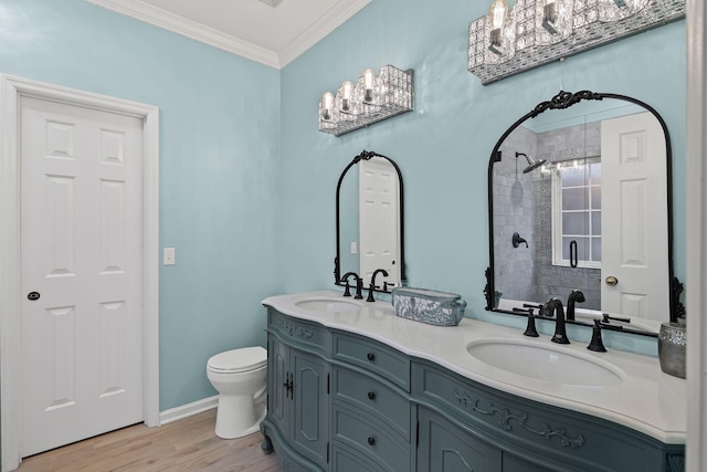 bathroom featuring tiled shower, toilet, crown molding, vanity, and hardwood / wood-style floors