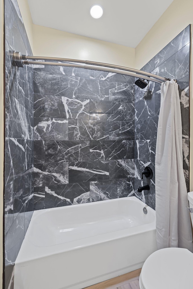 bathroom featuring shower / tub combo with curtain and toilet