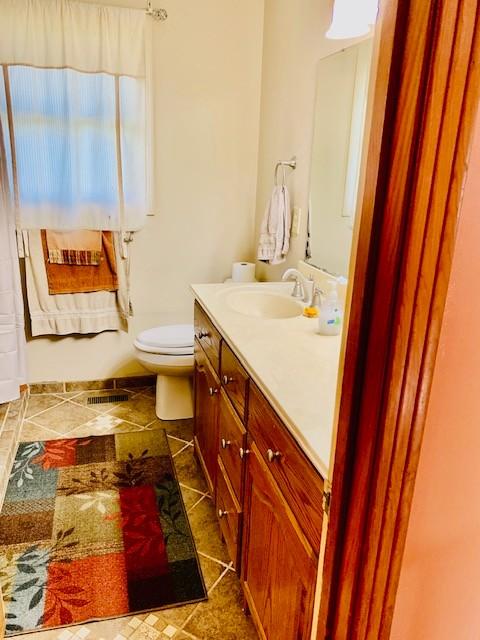 bathroom with tile patterned floors, vanity, and toilet