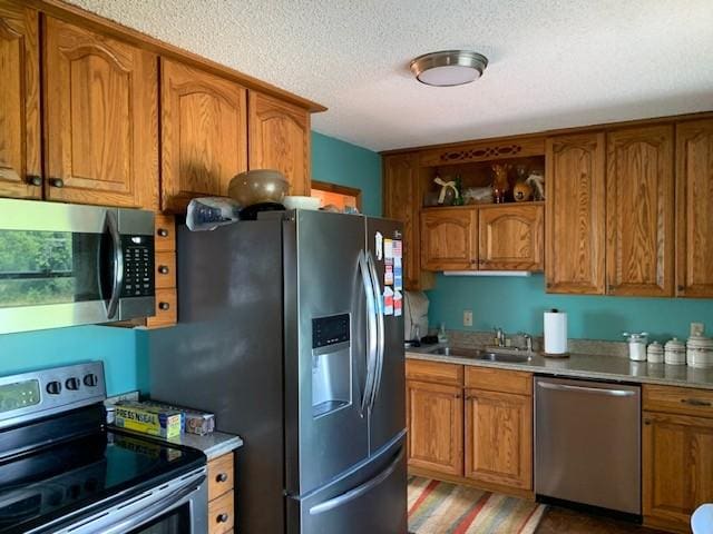 kitchen featuring stainless steel appliances, sink, and a textured ceiling