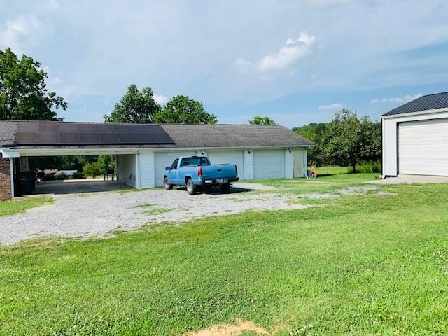 garage featuring a lawn and solar panels