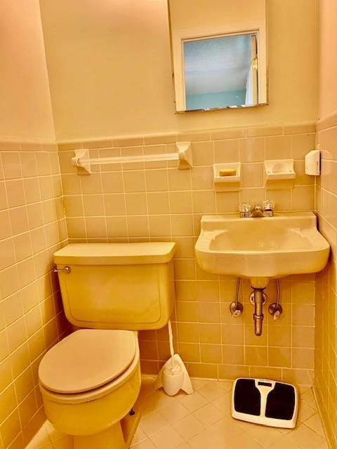 bathroom featuring tile patterned flooring, sink, tile walls, and toilet