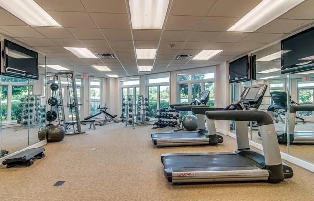 gym with a paneled ceiling and french doors