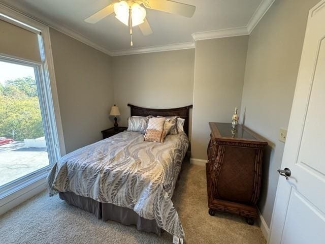 carpeted bedroom with ornamental molding and ceiling fan