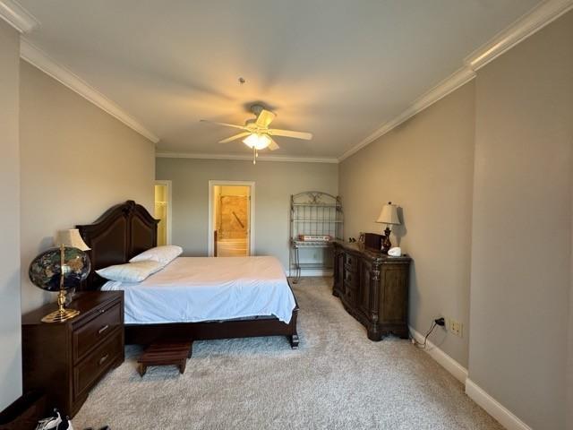 carpeted bedroom with ornamental molding and ceiling fan