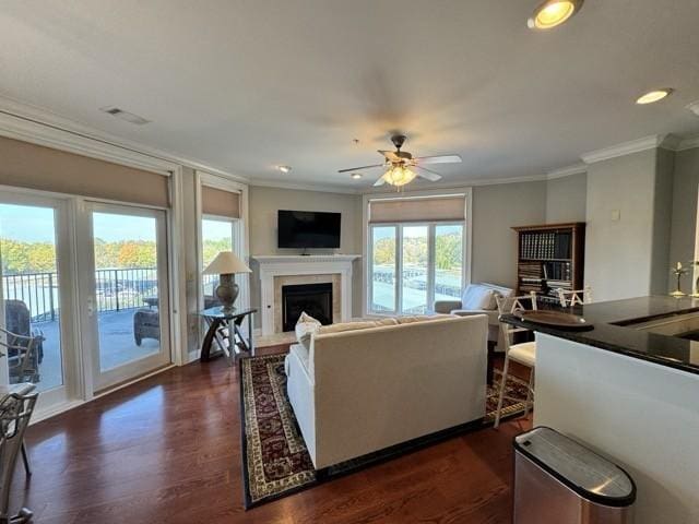 living room featuring crown molding, dark wood-type flooring, sink, and ceiling fan