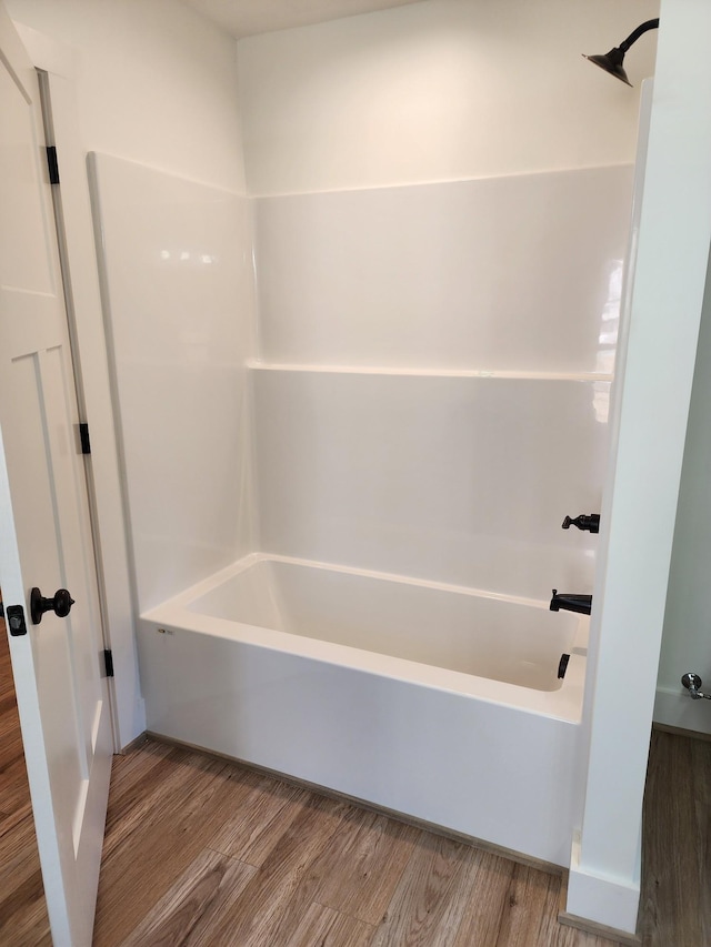 bathroom featuring wood-type flooring and tub / shower combination