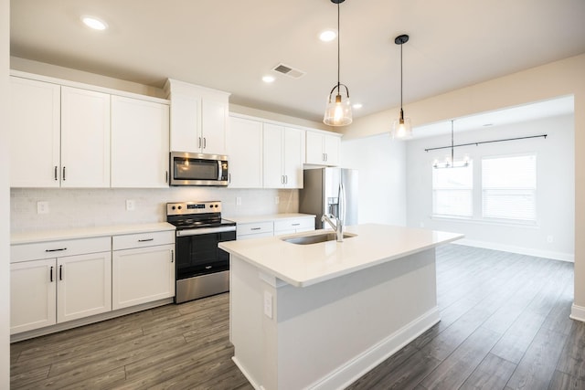 kitchen with stainless steel appliances, white cabinetry, a kitchen island with sink, and pendant lighting