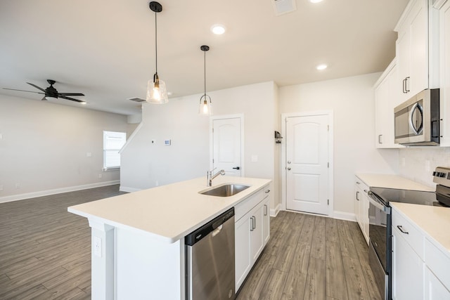 kitchen featuring white cabinetry, sink, hanging light fixtures, a kitchen island with sink, and stainless steel appliances