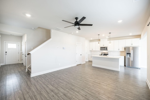 unfurnished living room featuring ceiling fan and light wood-type flooring