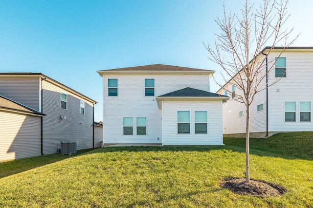 back of property featuring a yard and central AC