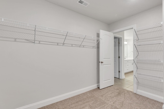 walk in closet featuring light colored carpet