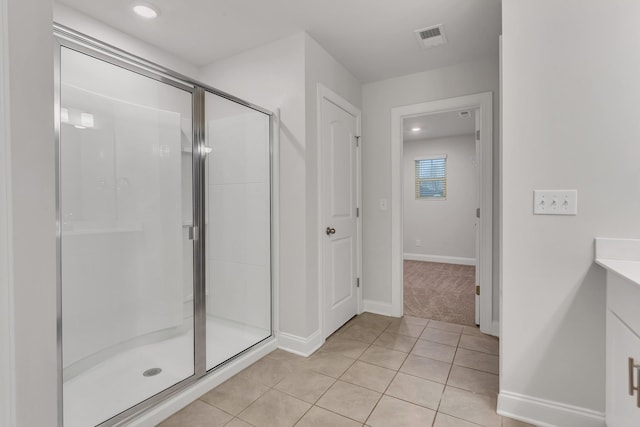 bathroom with an enclosed shower and tile patterned floors