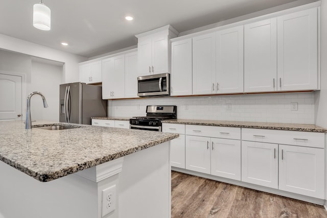 kitchen with white cabinetry, appliances with stainless steel finishes, and pendant lighting