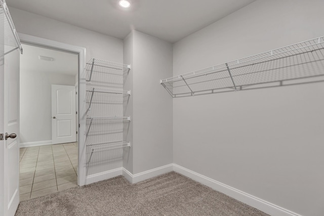 walk in closet featuring light colored carpet