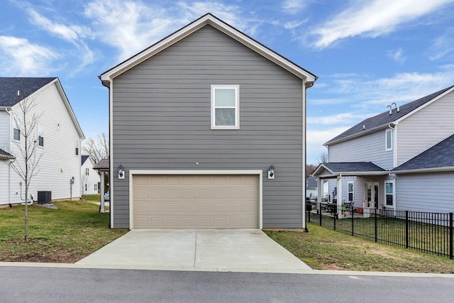 view of front of property with a garage, central AC unit, and a front yard