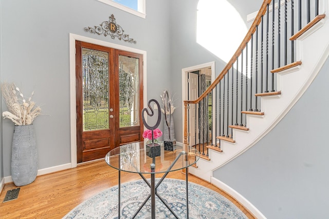 foyer entrance featuring stairway, wood finished floors, visible vents, and baseboards