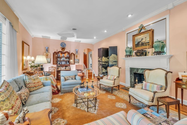 living room with hardwood / wood-style flooring, ornamental molding, and a high end fireplace