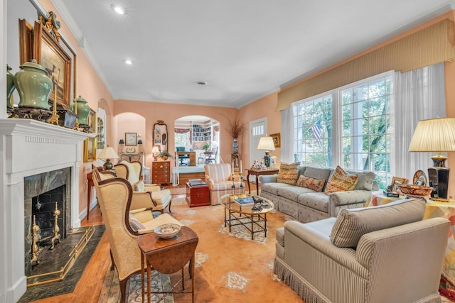 living room featuring crown molding, a fireplace, and light hardwood / wood-style flooring