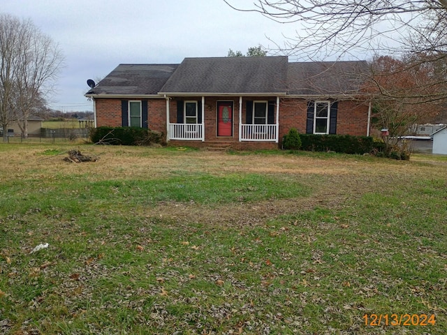 ranch-style home featuring a porch and a front lawn