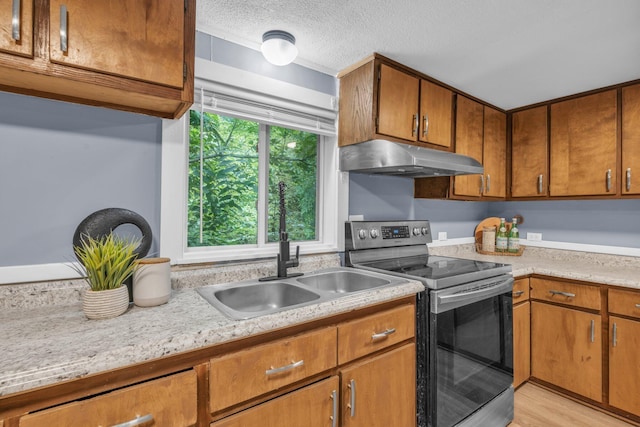 kitchen featuring stainless steel electric stove, sink, a textured ceiling, and light wood-type flooring