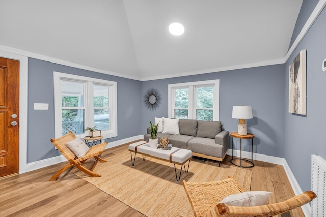 living room with lofted ceiling, a healthy amount of sunlight, and light wood-type flooring