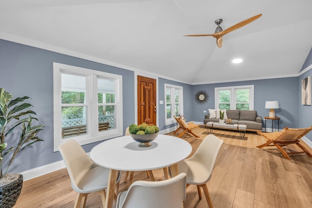 dining area with crown molding, light hardwood / wood-style flooring, ceiling fan, and vaulted ceiling