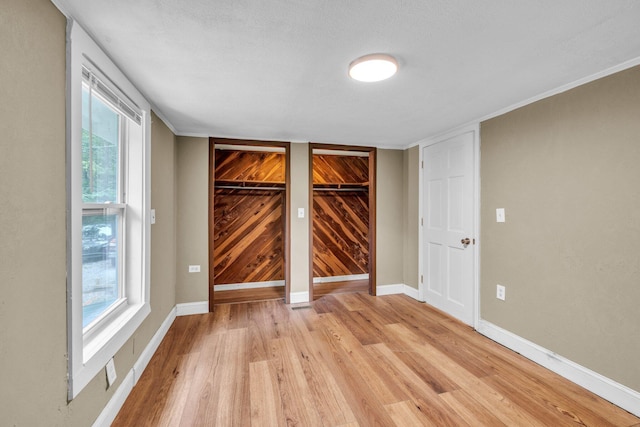 unfurnished room with a textured ceiling and light wood-type flooring