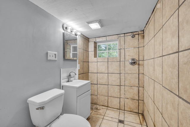 bathroom with vanity, a tile shower, and toilet