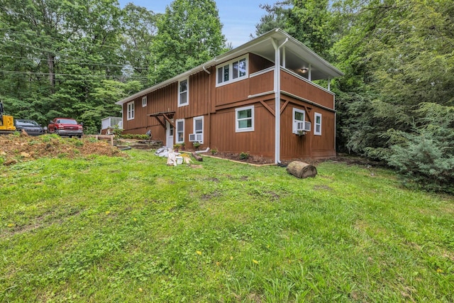 rear view of property featuring cooling unit and a lawn