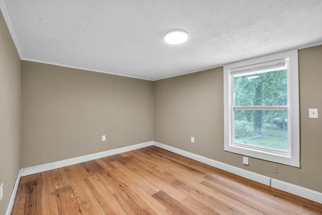 empty room with light hardwood / wood-style floors and a textured ceiling