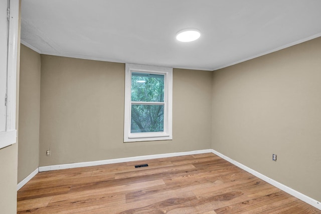 spare room with crown molding and light hardwood / wood-style floors