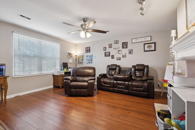 living room featuring dark wood-type flooring and ceiling fan