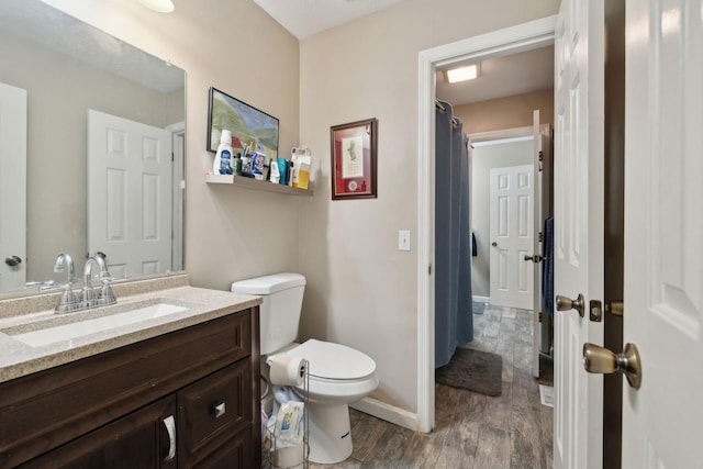 bathroom featuring vanity, toilet, and wood-type flooring