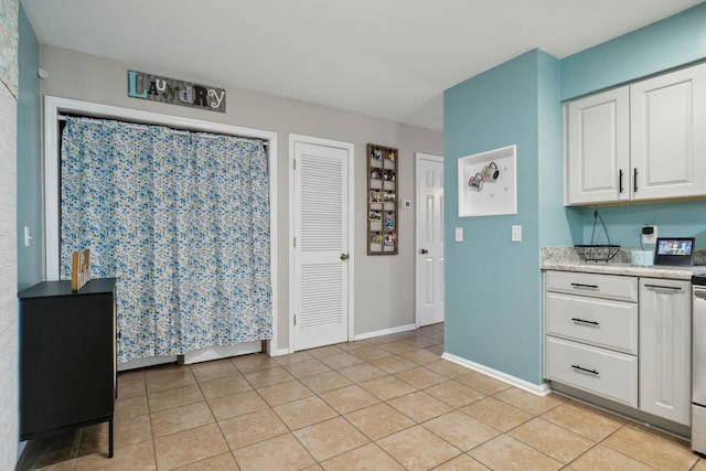 kitchen with white cabinetry and light tile patterned flooring