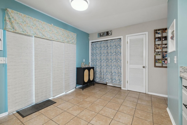 unfurnished bedroom featuring multiple closets and light tile patterned floors