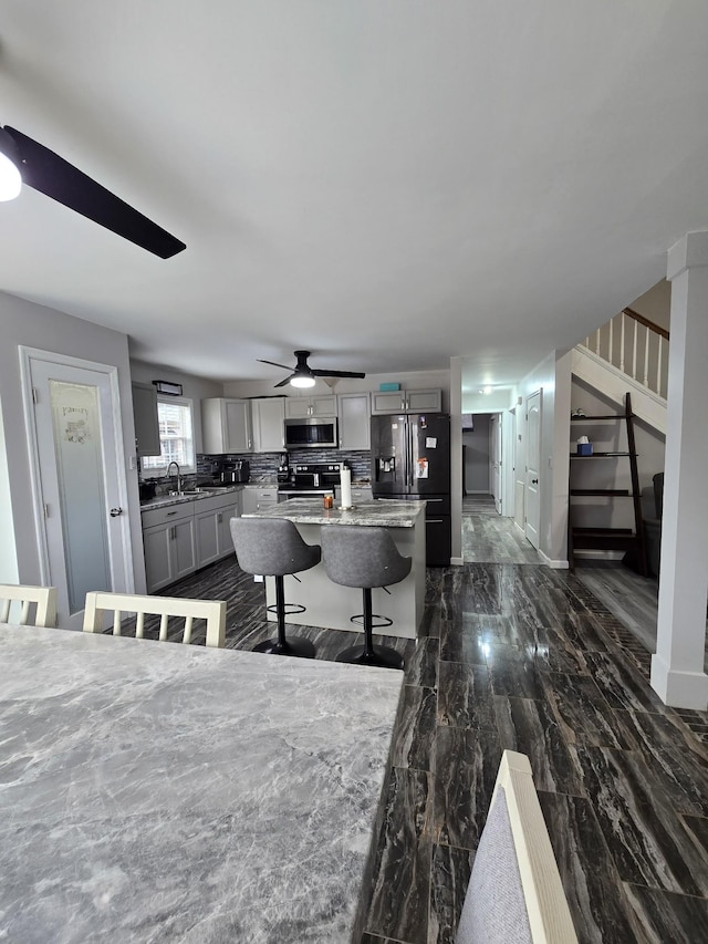 dining space featuring ceiling fan and sink