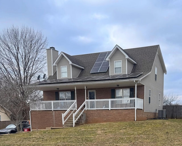 cape cod home featuring cooling unit, a porch, a front lawn, and solar panels