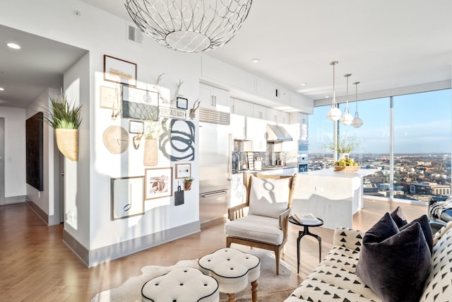 living room with a wall of windows and light parquet floors