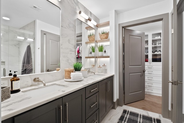 bathroom with vanity and a shower with door