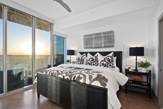 bedroom featuring parquet floors, expansive windows, and ceiling fan